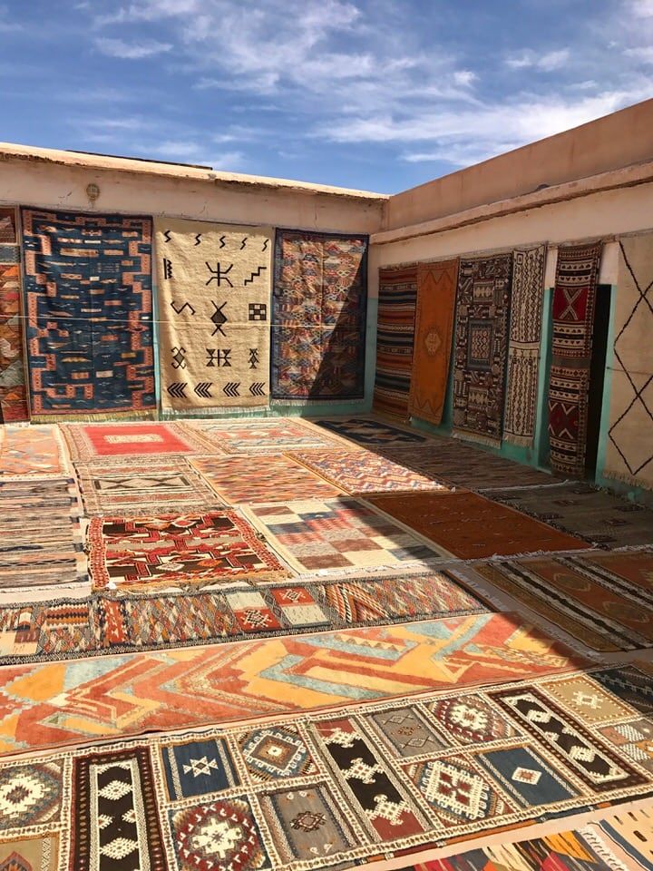 Moroccan artisan woman weaving traditional Berber rug by hand - IZRIN heritage craftsmanship