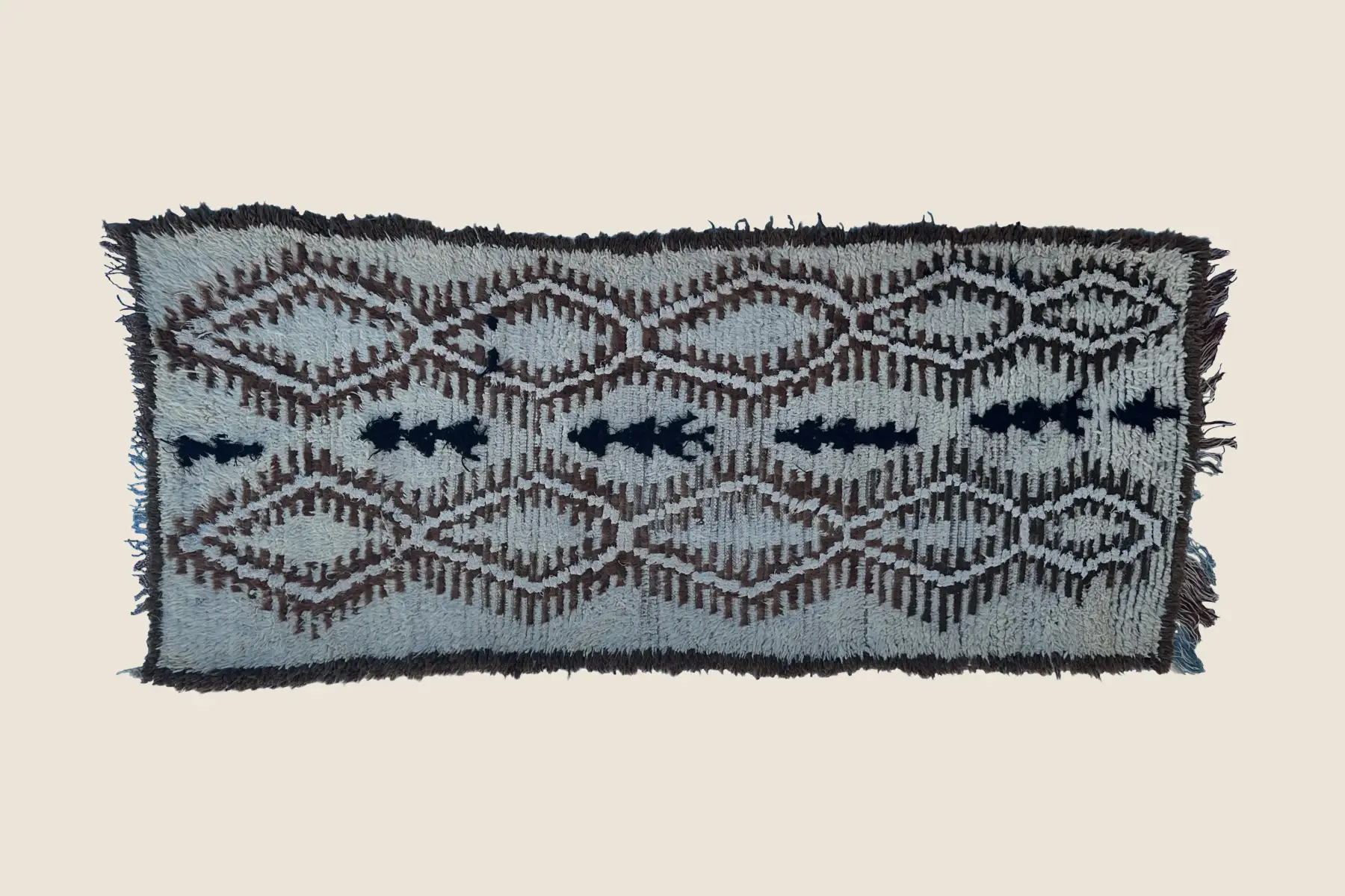 Beni M'Guild flat-weave wool detail showing navy and brown geometric motifs with hand-knotted texture