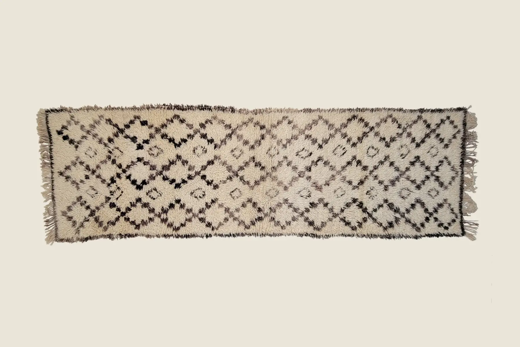 Beni Ourain high-pile texture detail showing hand-spun black wool and ivory background craftsmanship