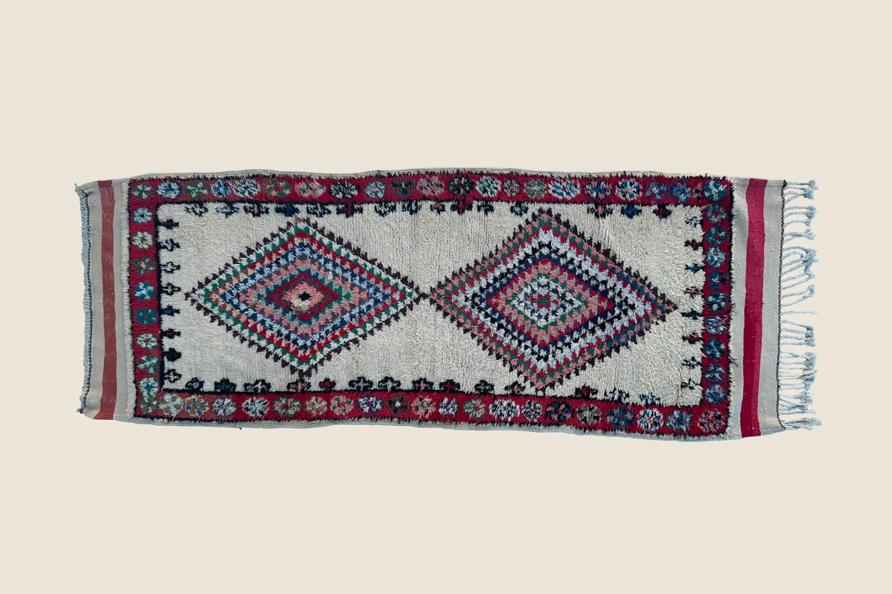 Azilal rug detail showing hand-woven geometric motif with gray-green, red, and teal wool texture