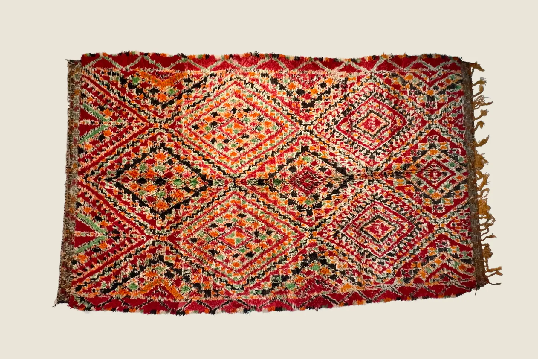 IZRIN - Beni M'Guild hand-knotted texture detail showing vibrant red and charcoal brown tribal pattern craftsmanship