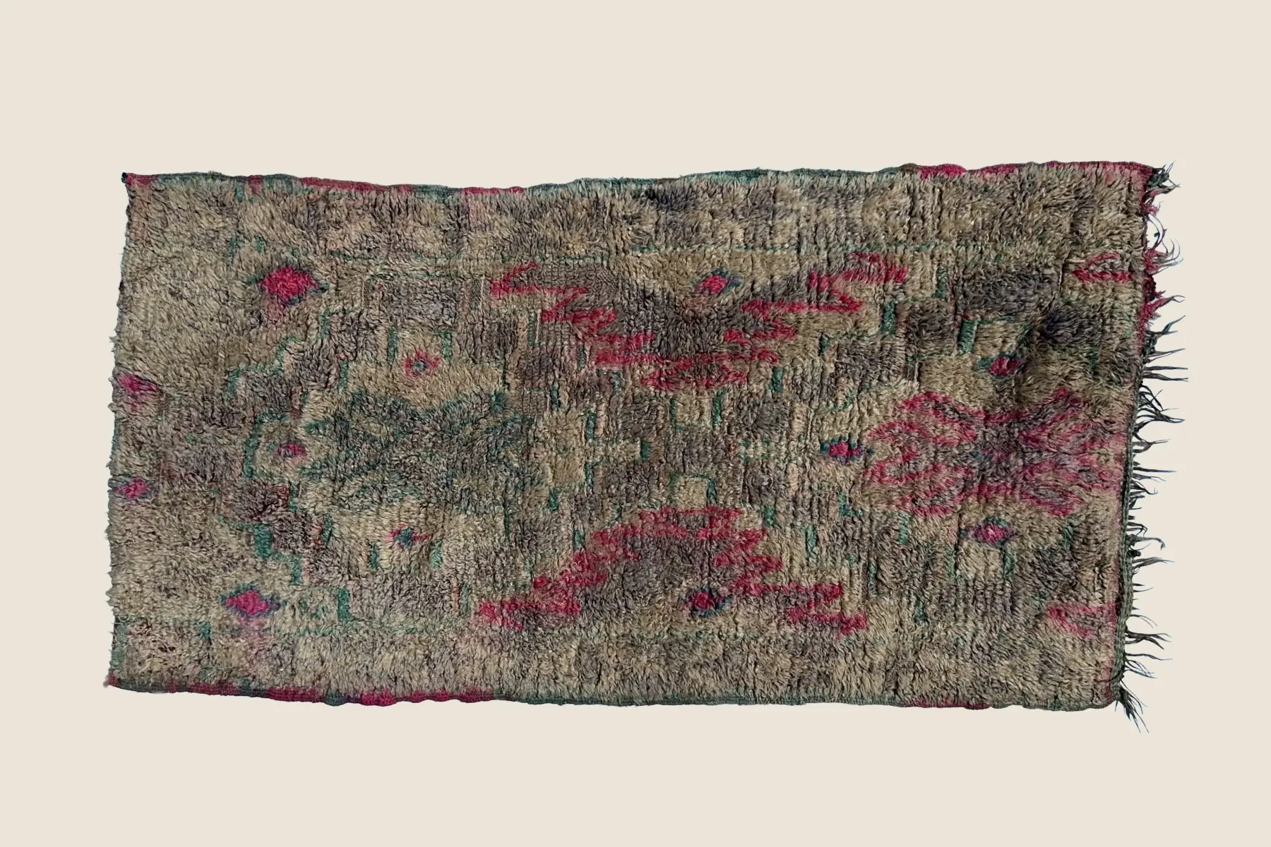 Boujad wool texture close-up showing hand-knotted beige and red weave with gray accents