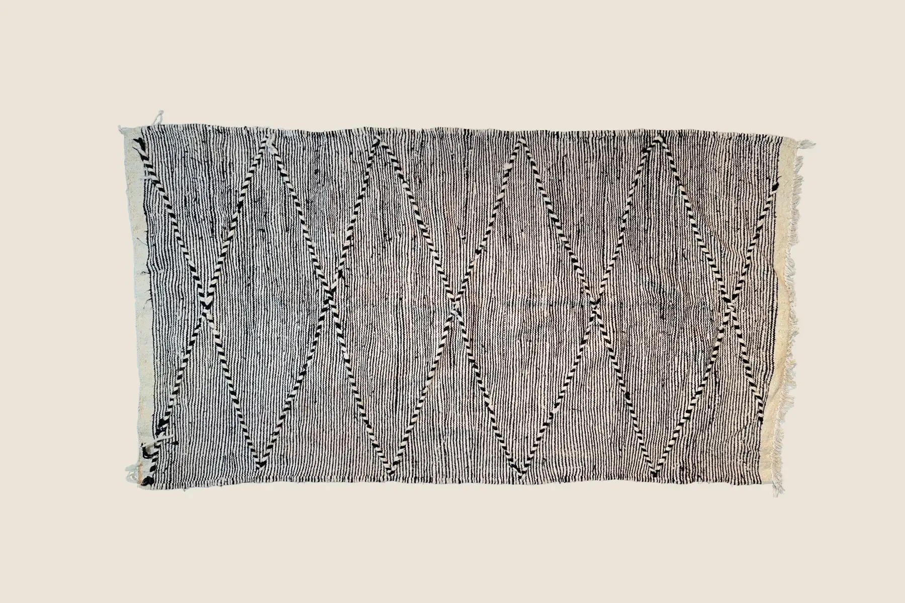 Boujad rug texture detail showing hand-knotted wool pile and charcoal gray geometric motifs