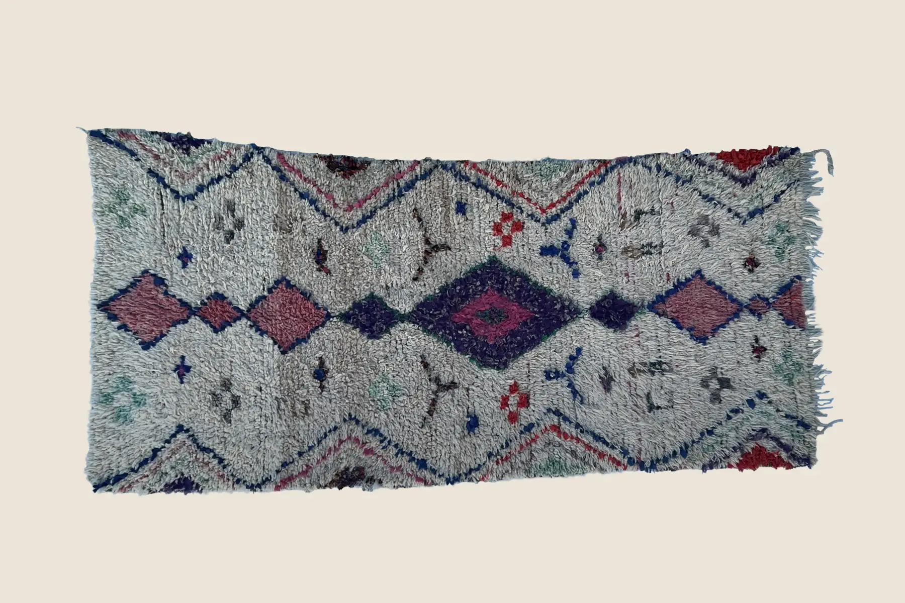 Beni M'Guild rug detail showing hand-knotted wool texture with warm rose and gray geometric motifs - artisan weaving craftsmanship