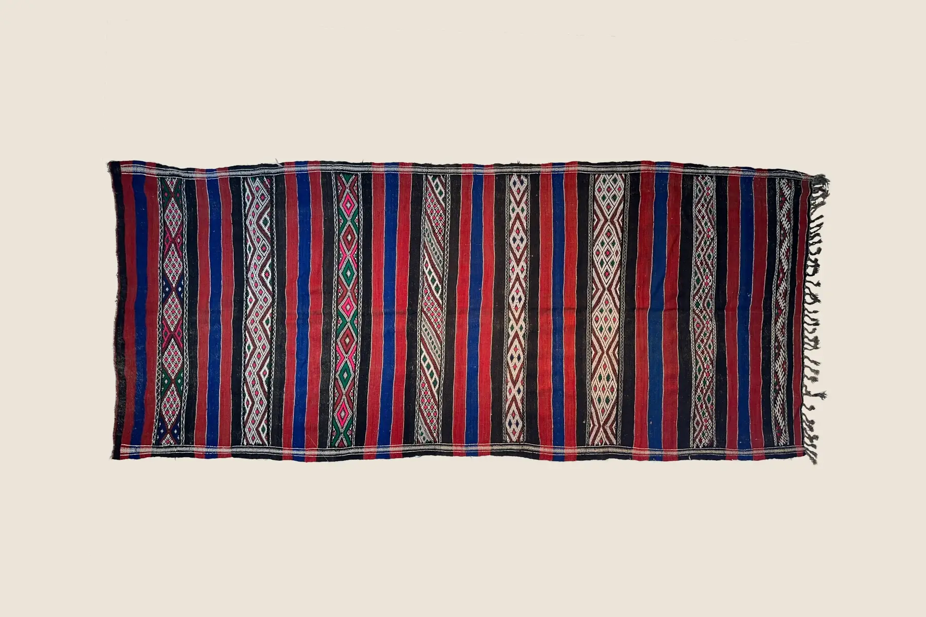 Kilim hand-weaving detail showing burnt orange and teal geometric pattern - handcrafted wool texture.