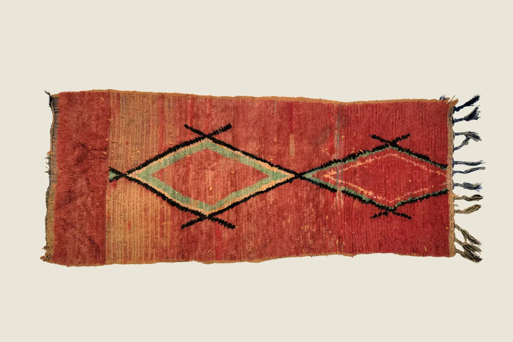 Beni M'Guild hand-knotted texture detail showing muted brick red and sage green wool craftsmanship