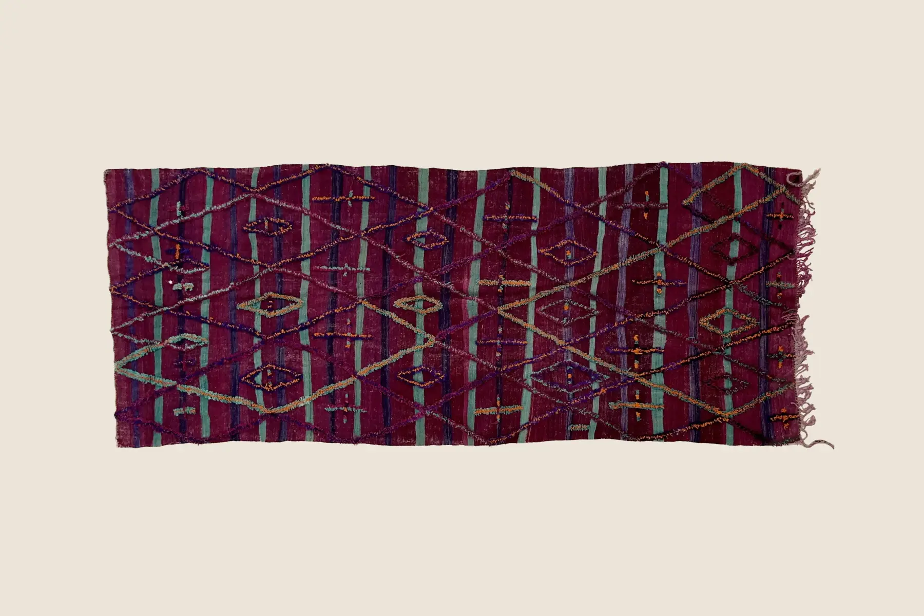 Talsint rug detail showing hand-knotted deep rose and teal wool pile texture and weaving craftsmanship