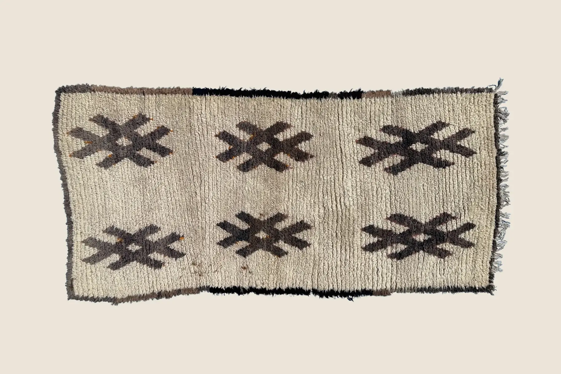 Talsint rug detail showing hand-woven wool texture and warm brown & ivory geometric pattern – Izrin craftsmanship