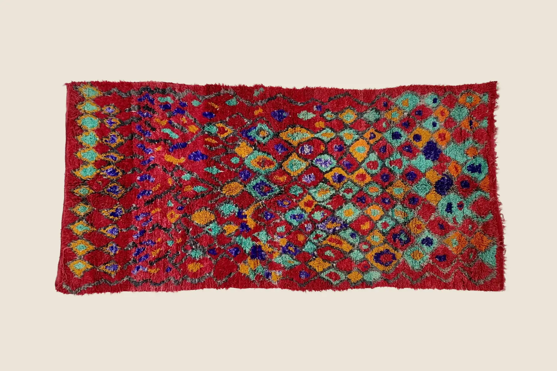 Talsint rug detail showing hand-knotted wool texture with vibrant red, sage, and purple motifs - Moroccan artisan weaving technique