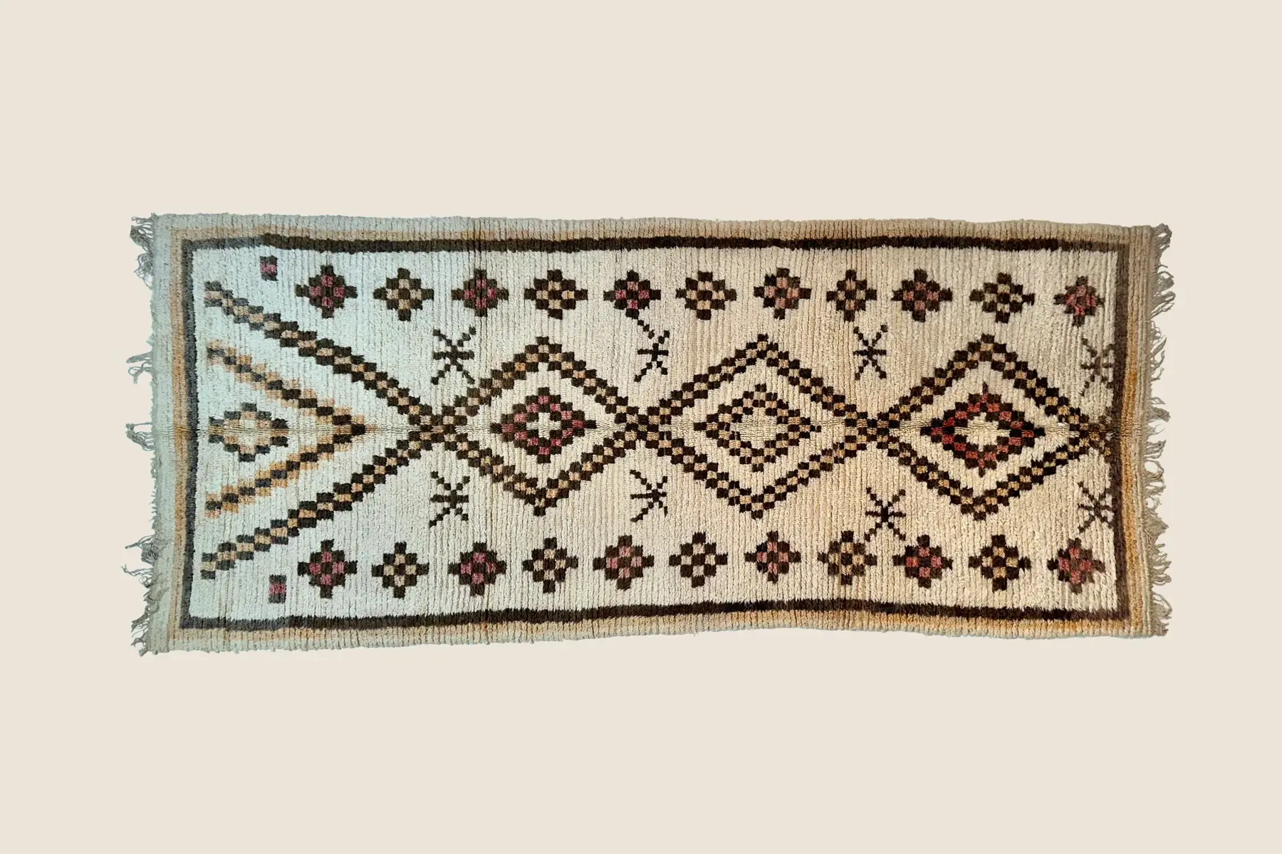 Talsint wool rug texture detail showing hand-tufted loop pile in light coral and warm beige