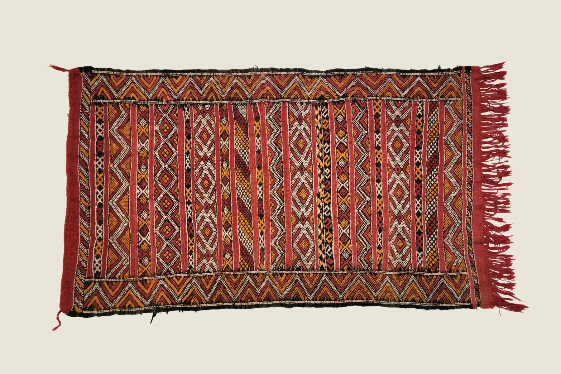 Kilim weave detail showing hand-spun wool texture and terracotta diamond pattern - traditional Moroccan craftsmanship.