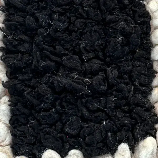 Dark charcoal color swatch for Handwoven Atlas Rug in warm earth tones and violet.