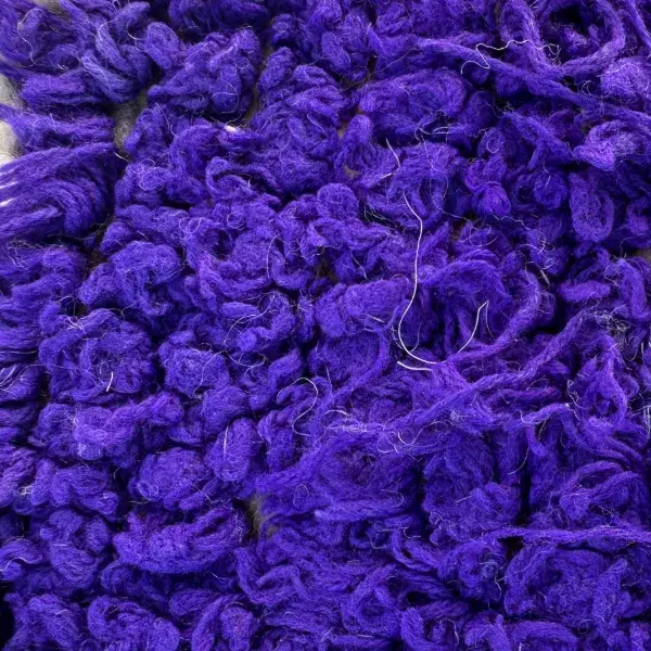 A color swatch labeled Deep Violet, a rich purple shade from the Handwoven Atlas Rug collection featuring warm earth tones and violet