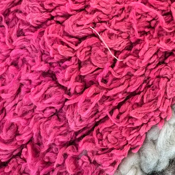 A color swatch labeled Warm Rose, a pink hue from the Handwoven Atlas Rug collection featuring warm earth tones and violet.