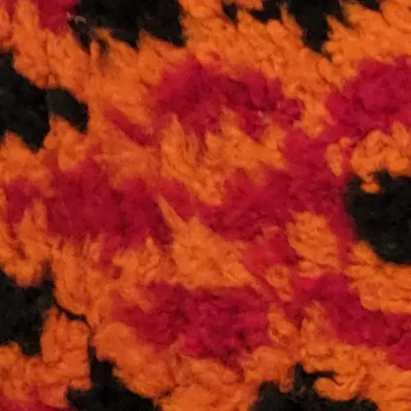 Burnt orange diamond pattern rug with black and red accents.