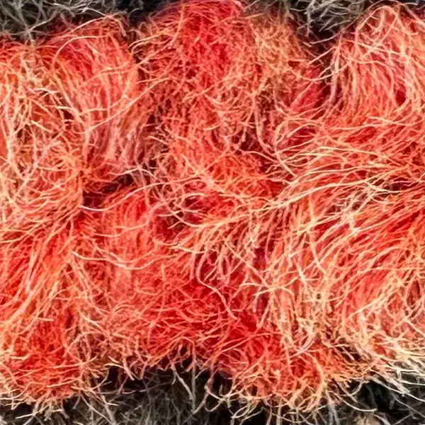 Burnt coral diamond pattern on red cotton fabric.