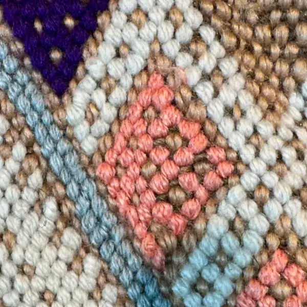 A light salmon pink diamond symbol on a red background.